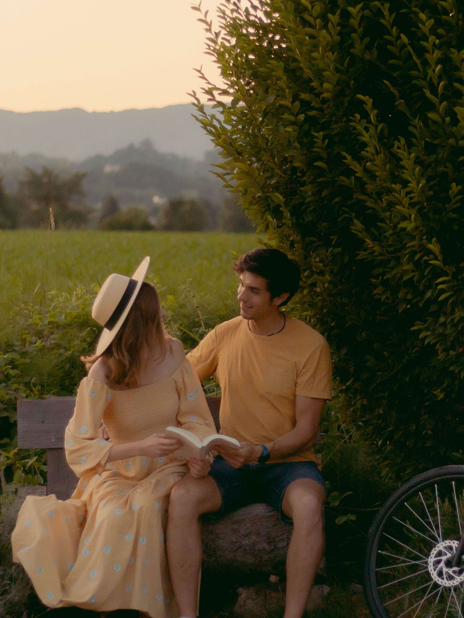 couple lisant un livre sur un banc