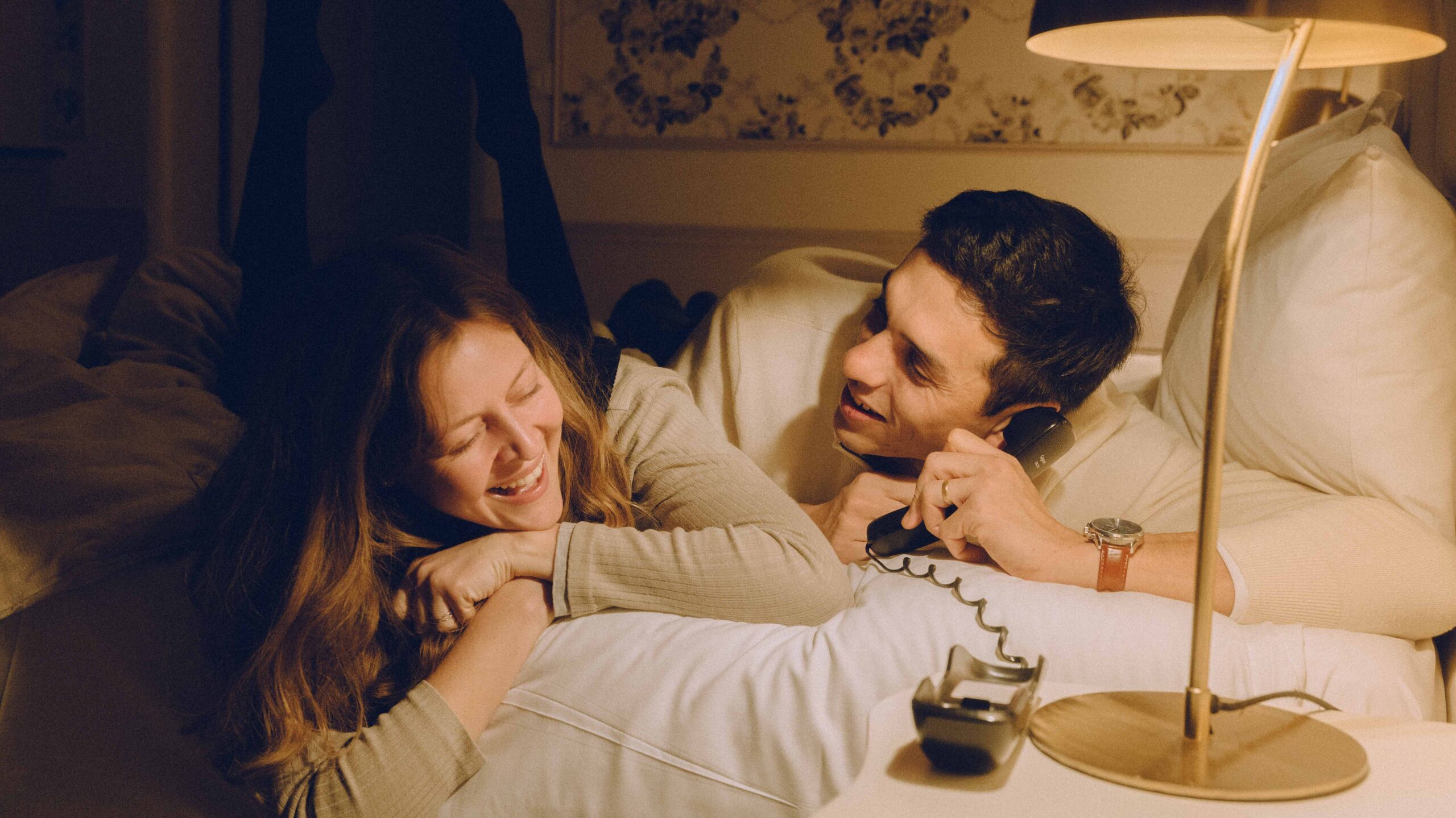 photo de couple qui rigole au téléphone comme s'il faisait un canular téléphonique