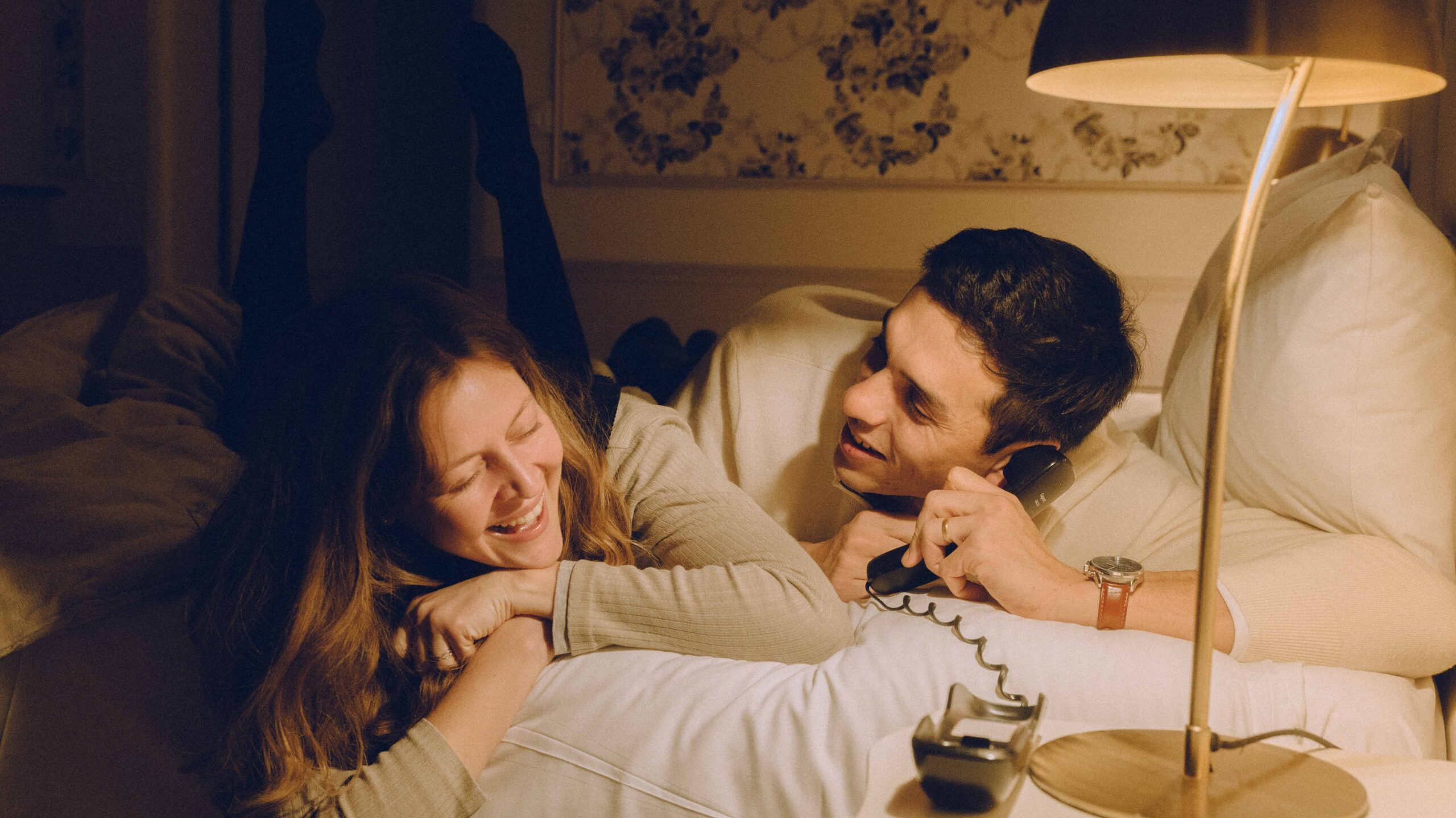 photo de couple qui rigole au téléphone comme s'il faisait un canular téléphonique