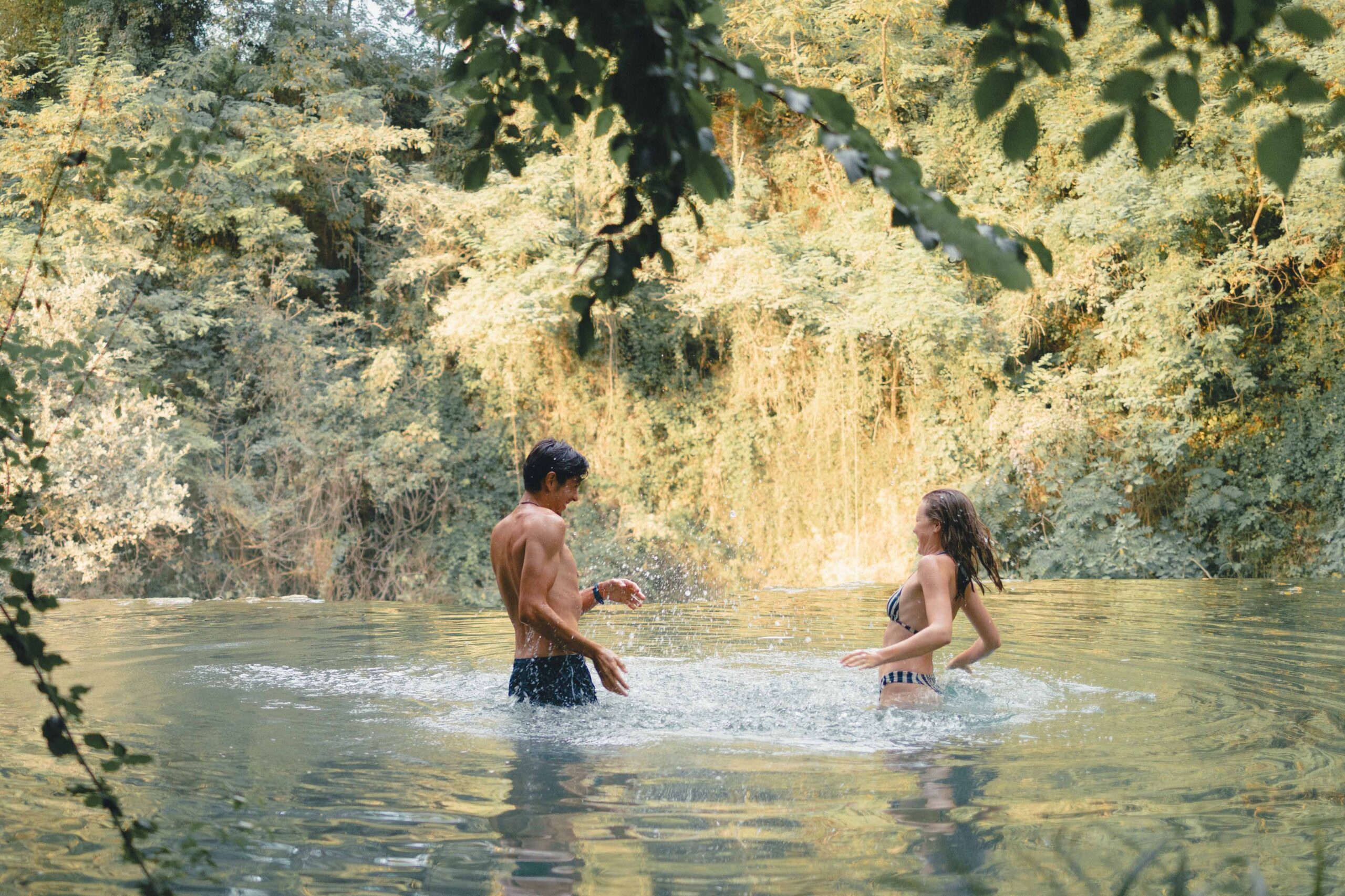 couple qui joue dans une rivière en s'éclaboussant